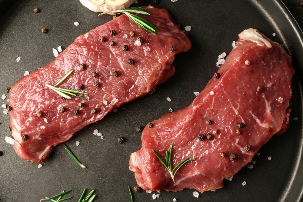 Fresh raw meat with spices on plate