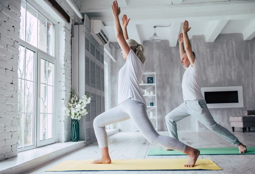 Couple is doing fitness training at home. Doing yoga together. Healthy lifestyle concept.